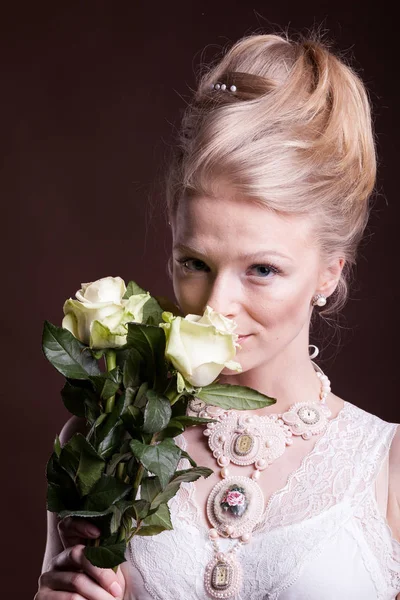 Blondynka w wiktoriańskiej sukienka z różami w ręce — Zdjęcie stockowe