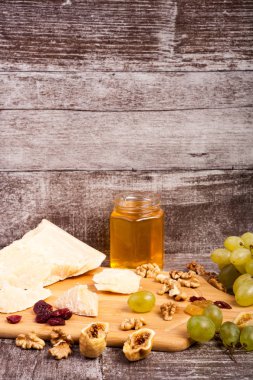 Üzüm, bal, peynir ve ceviz ahşap backgr üzerinde farklı tip