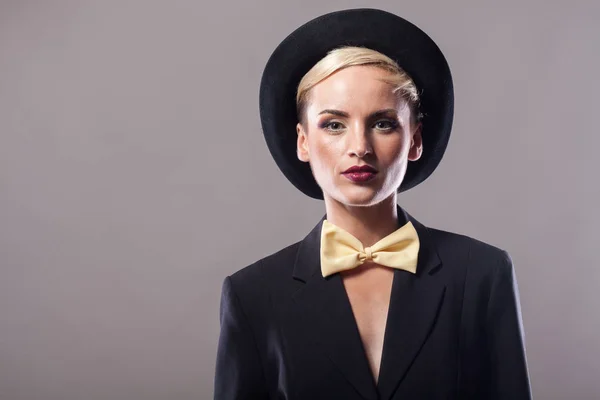 Hermosa mujer con sombrero sobre fondo gris — Foto de Stock