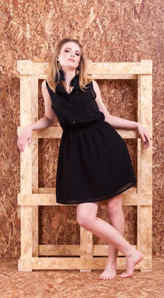 Belle femme style de mode posant sur un mur en bois — Photo
