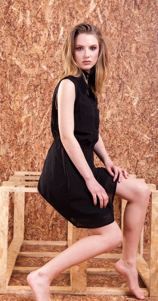 Шикарный женский стиль моды позирует на деревянной стене — стоковое фото
