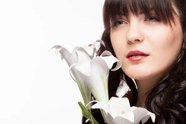 Splendida donna accanto a fiori su sfondo bianco — Foto Stock