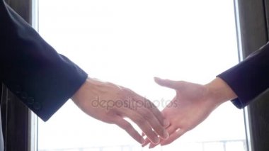 Bir iş adamı ve iş kadını arasında ağır çekimde el sıkışan