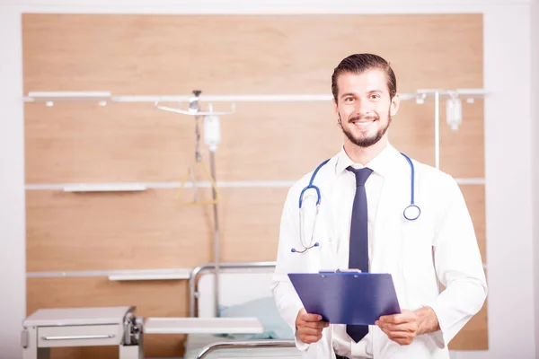 Doctor holding a folder in hands with stethoscope arround his ne — Stock Photo, Image