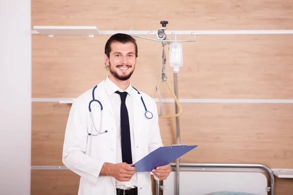 Medic holding a folder in hands with stethoscope arround his nec — Stock Photo, Image