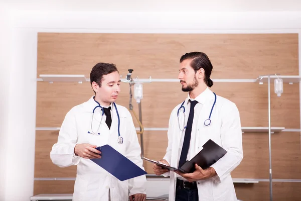 Two doctors in hospital recovery room talking — Stock Photo, Image
