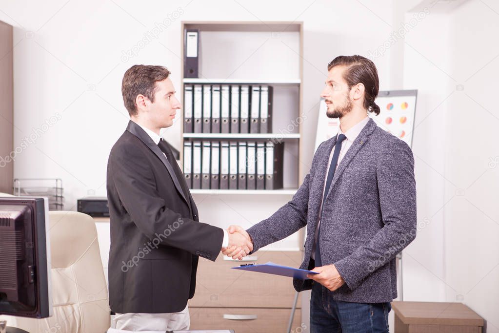 Young Business partners shaking hands in the office