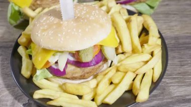 Yukarı kaydırma. Lezzletli ev yapımı hamburger ile kişiler üzerine ahşap masa