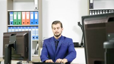 Tipik üstünde bilgisayar ve telefonda konuşurken iş kişi