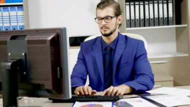 onun bilgisayar üzerinde çalışan iş adamı