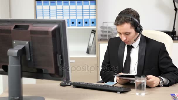 Businessman using headset to talk on the hot line — Stock Video