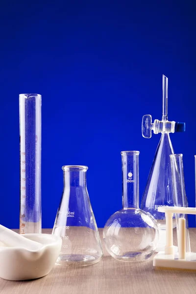Chemie lab ingesteld op tafel over blauwe achtergrond — Stockfoto