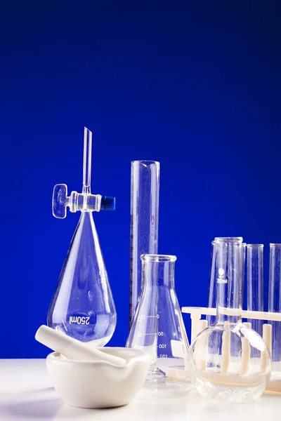 Chemielabor auf Tisch vor blauem Hintergrund — Stockfoto