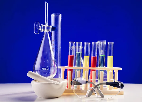 Εργαστήριο Χημείας που τίθεται σε ένα τραπέζι με προστατευτικά γυαλιά πέρα από blu — Φωτογραφία Αρχείου
