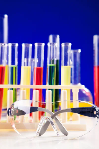 Vybavení laboratoře chemie na stůl nad modrým pozadím — Stock fotografie