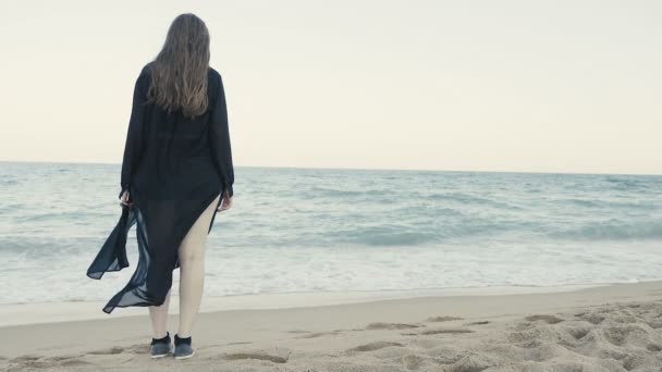 Kadın siyah uzun sallayarak Fularlı beack üzerinde yürüme — Stok video