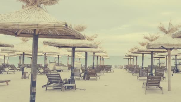Сонячні ліжка і парасольки біля пляжу — стокове відео