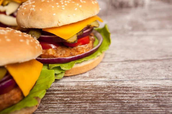 Delicious tasty burgers on wooden background