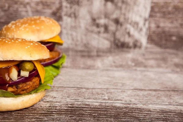 Délicieux hamburgers savoureux sur fond de bois — Photo