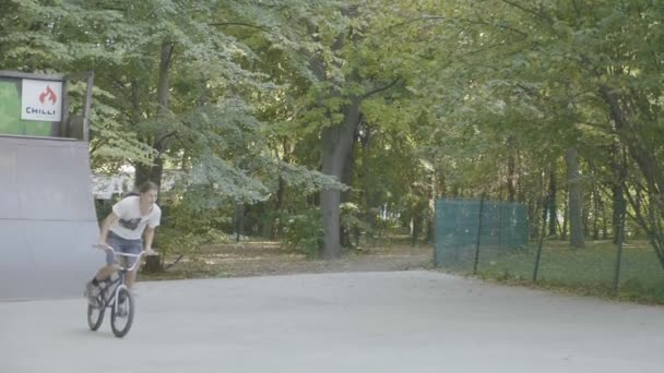 Adolescente sulla BMX facendo triks nel parco — Video Stock