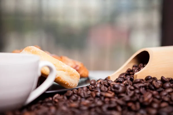 Coffee beans, donut and a cup of coffee