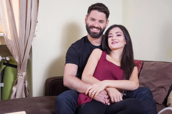 Casal jovem, masculino abraçando a mulher e sorrindo para a câmera — Fotografia de Stock