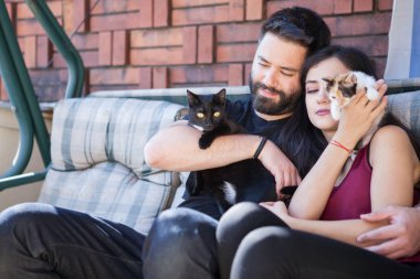 Muhteşem güzel genç çift holding kediler elinde