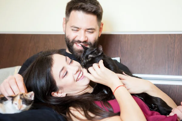 Young inlove couple on the bed with their cats — Stock Photo, Image