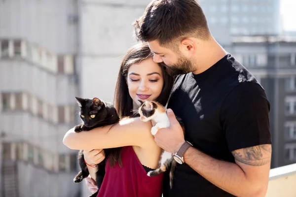 Junges Paar hält Katzen auf der Terrasse in den Händen — Stockfoto