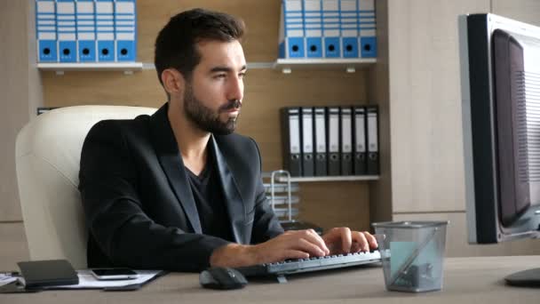 Jeune homme d'affaires à son bureau tapant sur l'ordinateur — Video