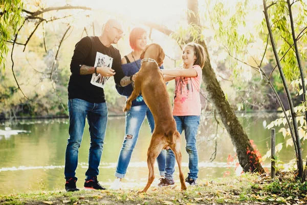 Aile baba, anne ve kızı nehir kenarında oynarken w — Stok fotoğraf