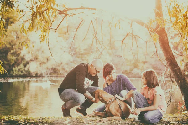 Família de pai, mãe e filha na beira do rio jogando w — Fotografia de Stock