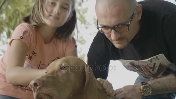 Familia de tres en el parque jugando con su perro — Vídeos de Stock