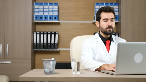 Docteur dans son bureau à l'ordinateur portable — Video