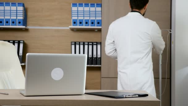 Arzt in seinem Büro am Laptop — Stockvideo