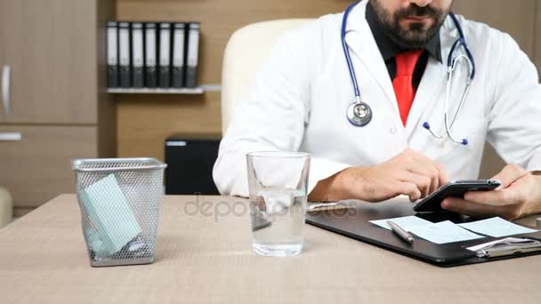 Docteur dans son bureau à l'ordinateur portable — Video