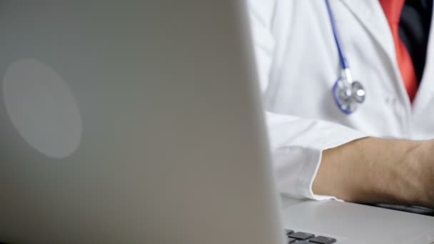 Gros plan dolly shot of doctor hands looking on tablet in his cabinet — Video