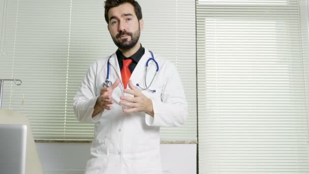 Jeune médecin dans son bureau parlant à la caméra — Video