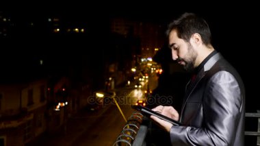Tablet Pc kullanma balkon, resmi elbiseli genç işadamı