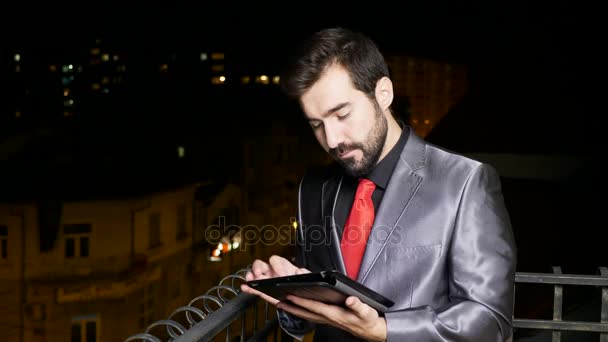 Giovane uomo d'affari in abito formale al balcone utilizzando un tablet PC — Video Stock