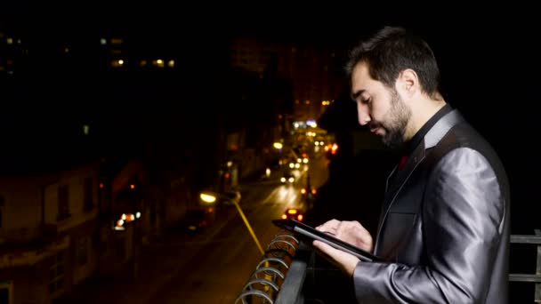 Giovane uomo d'affari in abito formale al balcone utilizzando un tablet PC — Video Stock