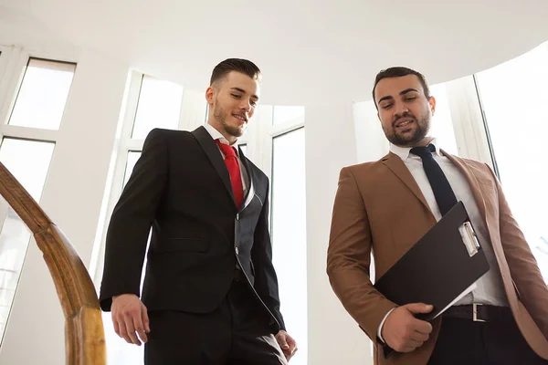 Geschäftspartner im formellen Anzug gehen und reden — Stockfoto