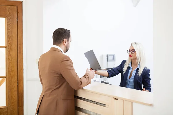 Geschäftsmann im Büro-Empfangsbereich im Gespräch mit Sekretärin — Stockfoto