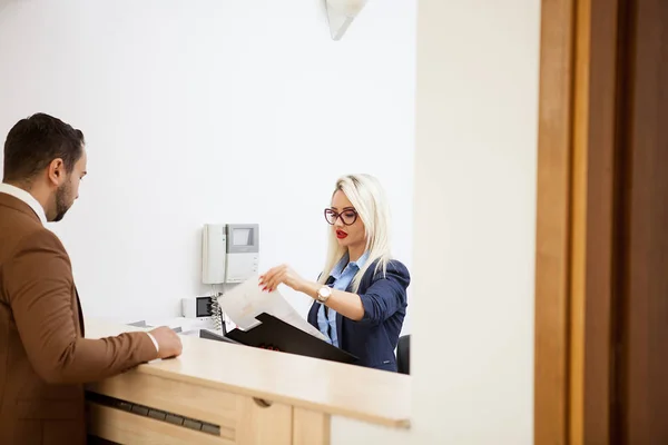 Empresário na área de recepção do escritório conversando com secretário — Fotografia de Stock