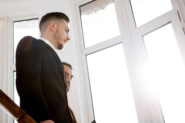 Two business men in the rays of light in office — Stock Photo, Image