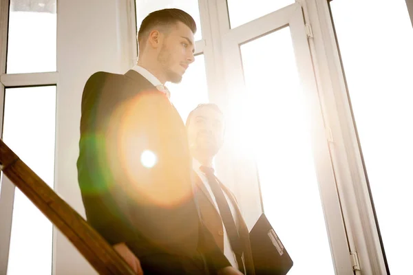 Two business men in the rays of light in office — Stock Photo, Image