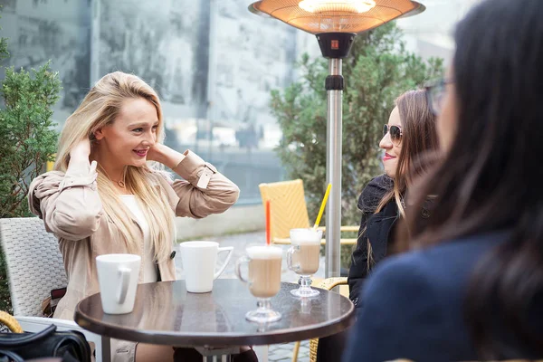 Porträt der schönen blonden Frau im Gespräch mit ihren Freunden bei c — Stockfoto
