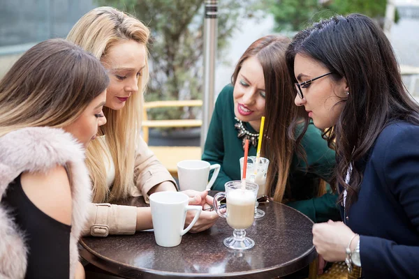 Группа подруг на террасе кофеина в червяке осенью глядя — стоковое фото