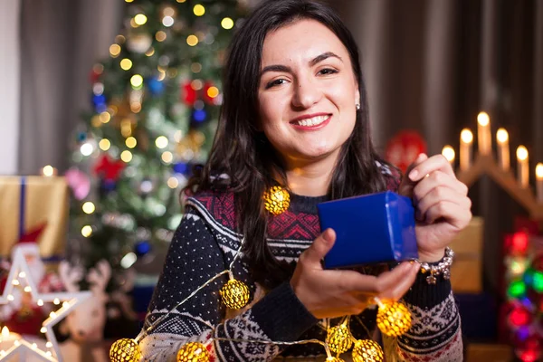 Retrato de mulher morena segurando uma caixa de presente azul nas mãos — Fotografia de Stock