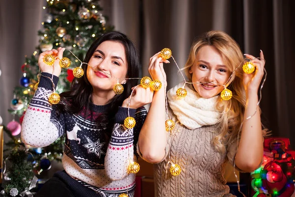 Sourire et s'amuser. Deux filles dans la chambre décorée de Noël — Photo